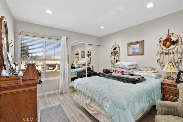 bedroom featuring light wood-type flooring, recessed lighting, and a closet