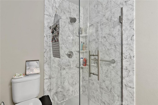 full bathroom with a marble finish shower and toilet