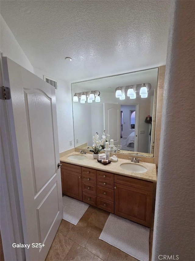 412 Arenoso Ln Unit 102, San Clemente, CA 92672 - bathroom with ensuite bathroom, double vanity, tile patterned floors, and a textured ceiling