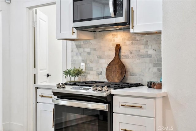 kitchen with light countertops, decorative backsplash, stainless steel appliances, and white cabinetry