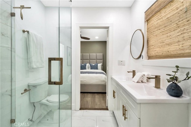ensuite bathroom featuring connected bathroom, vanity, toilet, marble finish floor, and a marble finish shower