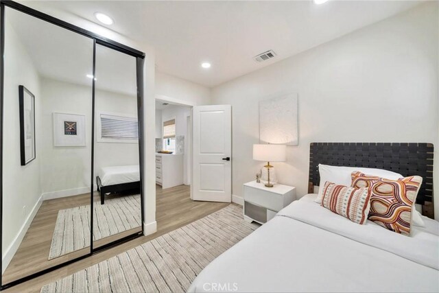 bedroom with visible vents, recessed lighting, baseboards, and wood finished floors