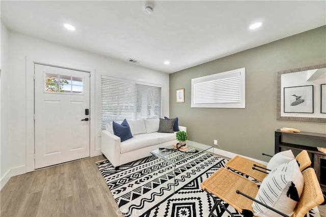 living room with light wood-style floors, baseboards, recessed lighting, and visible vents