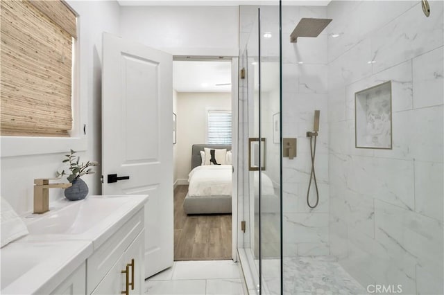 bathroom featuring vanity, connected bathroom, and a marble finish shower