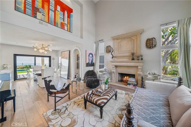 2009 Via Aguila, San Clemente, CA 92673 - living area with a lit fireplace, a chandelier, wood-type flooring, and a towering ceiling