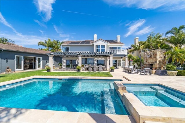2009 Via Aguila, San Clemente, CA 92673 - rear view of house with a pergola, a patio, roof mounted solar panels, an outdoor stone fireplace, and a chimney