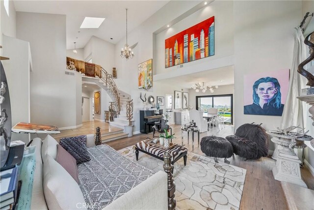 2009 Via Aguila, San Clemente, CA 92673 - living room featuring a chandelier, a towering ceiling, wood finished floors, a skylight, and stairway