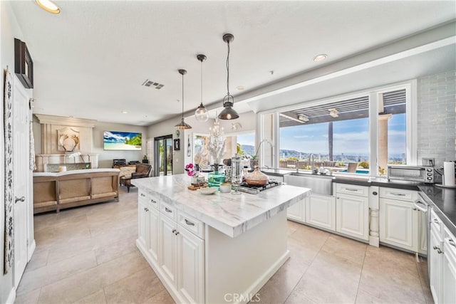 2009 Via Aguila, San Clemente, CA 92673 - kitchen with a kitchen island, open floor plan, white cabinetry, light tile patterned flooring, and pendant lighting