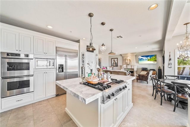 2009 Via Aguila, San Clemente, CA 92673 - kitchen with built in appliances, light tile patterned floors, white cabinetry, a kitchen island, and open floor plan
