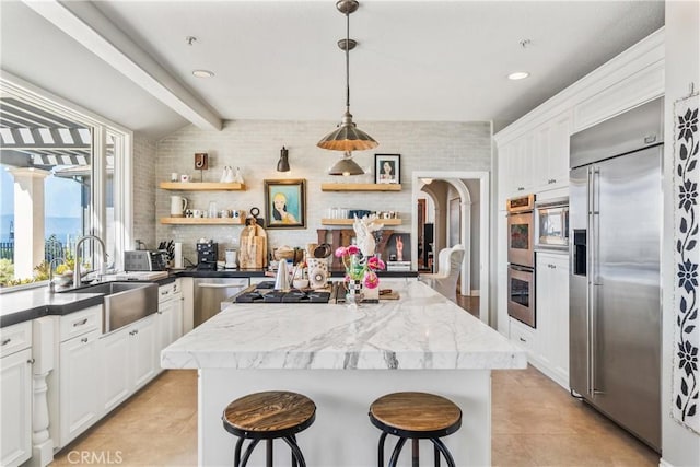 2009 Via Aguila, San Clemente, CA 92673 - kitchen with built in appliances, a center island, open shelves, light tile patterned floors, and white cabinets