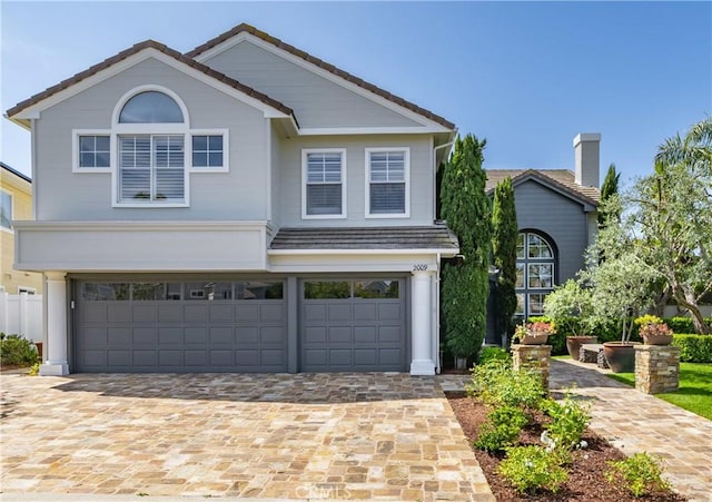 2009 Via Aguila, San Clemente, CA 92673 - traditional-style home featuring an attached garage, decorative driveway, a tile roof, and a chimney