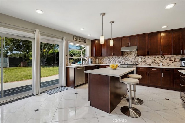 10313 Christine Pl, Chatsworth, CA 91311 - kitchen featuring appliances with stainless steel finishes, light countertops, backsplash, under cabinet range hood, and recessed lighting