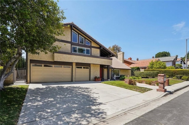 10313 Christine Pl, Chatsworth, CA 91311 - view of front facade with stucco siding, an attached garage, concrete driveway, a gate, and a chimney