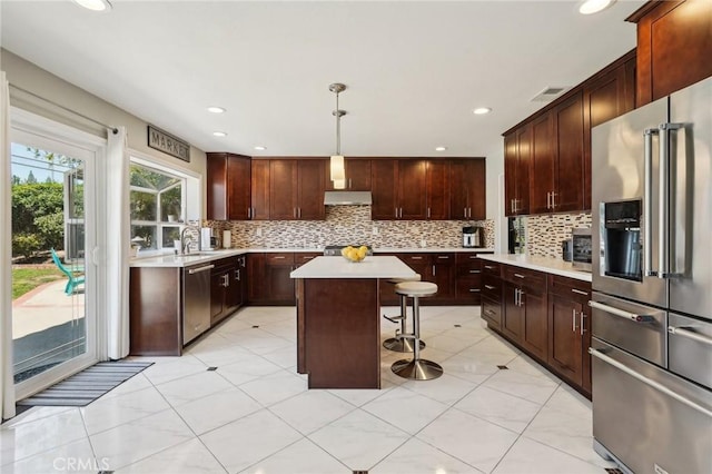 10313 Christine Pl, Chatsworth, CA 91311 - kitchen with appliances with stainless steel finishes, light countertops, a sink, a breakfast bar, and tasteful backsplash