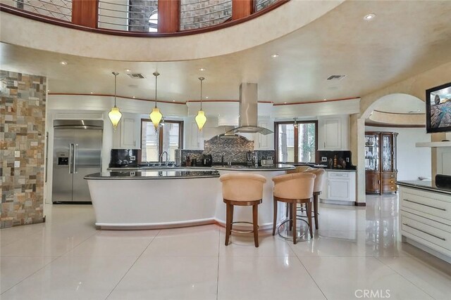 5455 E Sorrento Dr, Long Beach, CA 90803 - kitchen featuring stainless steel built in refrigerator, decorative backsplash, island range hood, dark countertops, and visible vents
