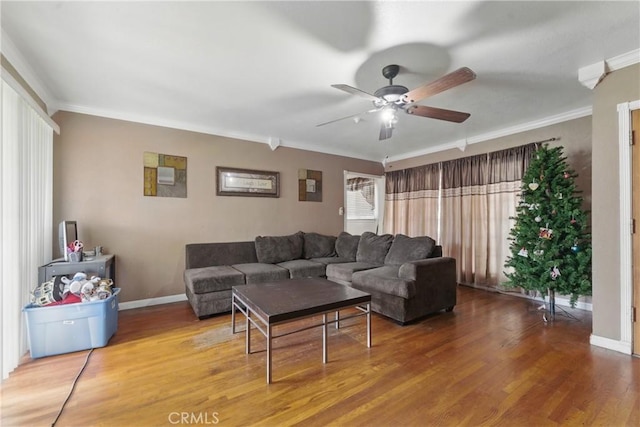 living room with a ceiling fan, baseboards, ornamental molding, and wood finished floors