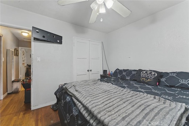 bedroom featuring baseboards, a ceiling fan, a closet, and wood finished floors