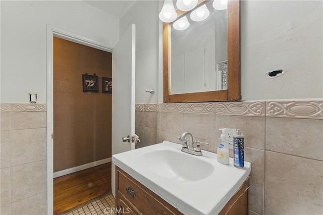bathroom with tile walls, a wainscoted wall, and vanity