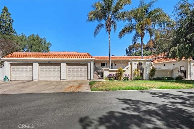 5472 Paseo Del Lago E Unit B, Laguna Woods, CA 92637 - mediterranean / spanish-style home featuring a tile roof, stucco siding, concrete driveway, and a garage