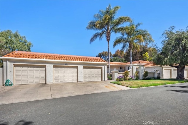 5472 Paseo Del Lago E Unit B, Laguna Woods, CA 92637 - view of front of house with a tiled roof, stucco siding, a garage, and driveway