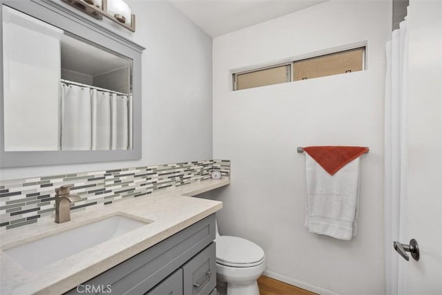 5472 Paseo Del Lago E Unit B, Laguna Woods, CA 92637 - full bath featuring tasteful backsplash, vanity, toilet, baseboards, and wood finished floors