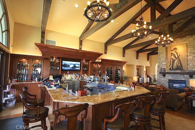 5472 Paseo Del Lago E Unit B, Laguna Woods, CA 92637 - indoor bar featuring a chandelier, high vaulted ceiling, beamed ceiling, a stone fireplace, and decorative light fixtures