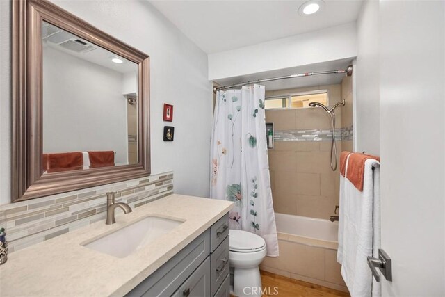 5472 Paseo Del Lago E Unit B, Laguna Woods, CA 92637 - bathroom featuring backsplash, toilet, vanity, shower / bathtub combination with curtain, and wood finished floors