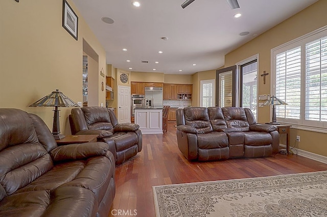 living area featuring visible vents, baseboards, recessed lighting, dark wood-type flooring, and a ceiling fan
