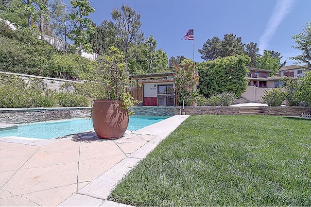 pool featuring a patio, a fenced backyard, and a yard