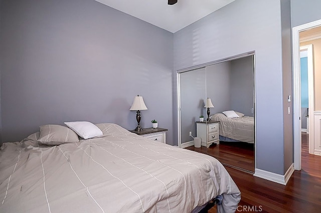 bedroom featuring baseboards, wood finished floors, and a closet