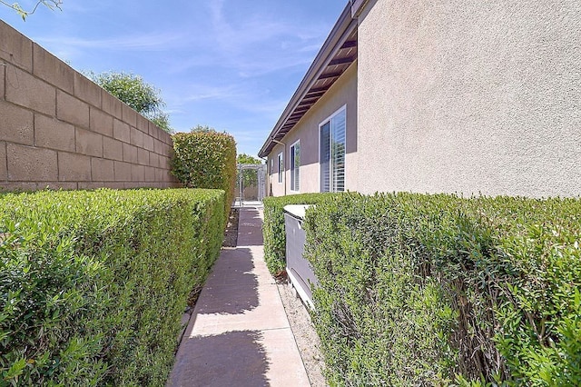 view of property exterior with stucco siding and fence