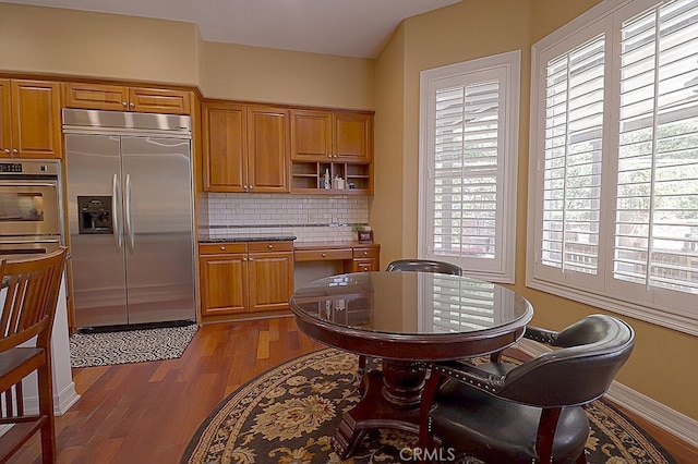 kitchen featuring brown cabinets, open shelves, backsplash, appliances with stainless steel finishes, and dark wood finished floors