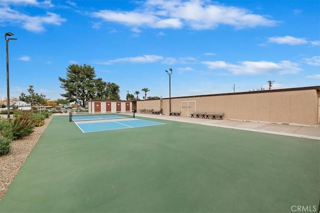 view of property's community featuring fence and a tennis court