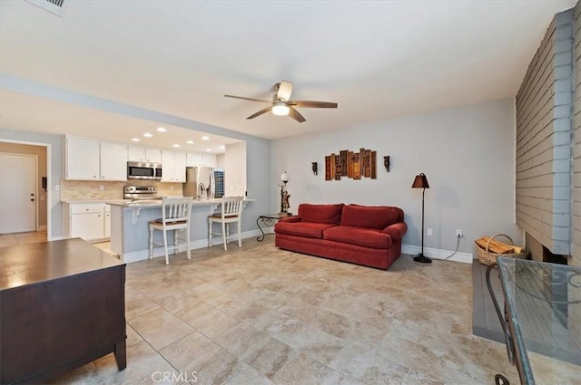 living room featuring recessed lighting, ceiling fan, and baseboards