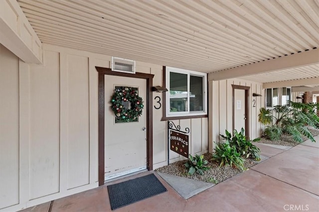 entrance to property with covered porch and board and batten siding