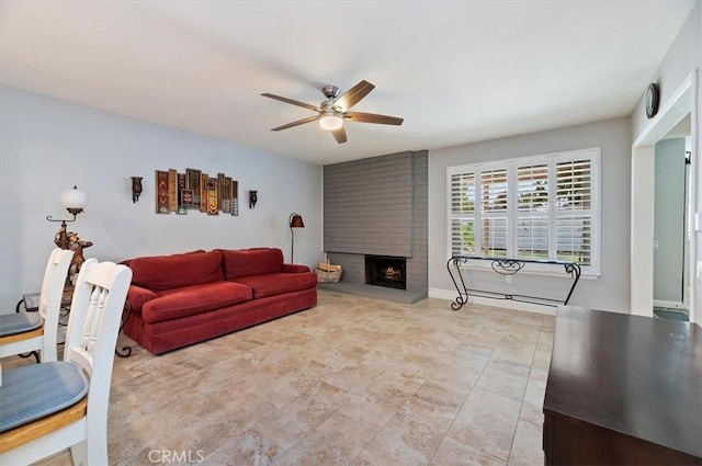 living area featuring a ceiling fan and a fireplace