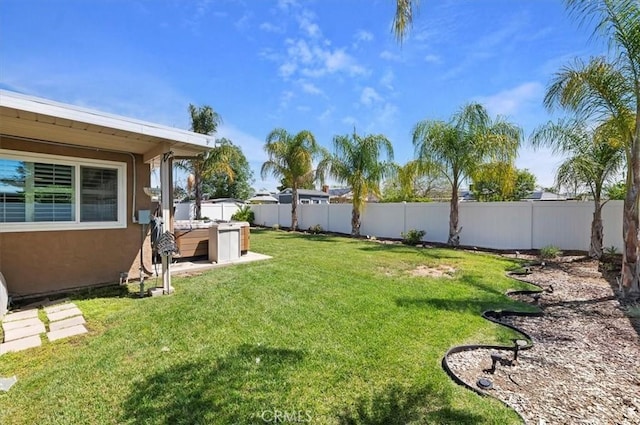 view of yard with a fenced backyard and a hot tub