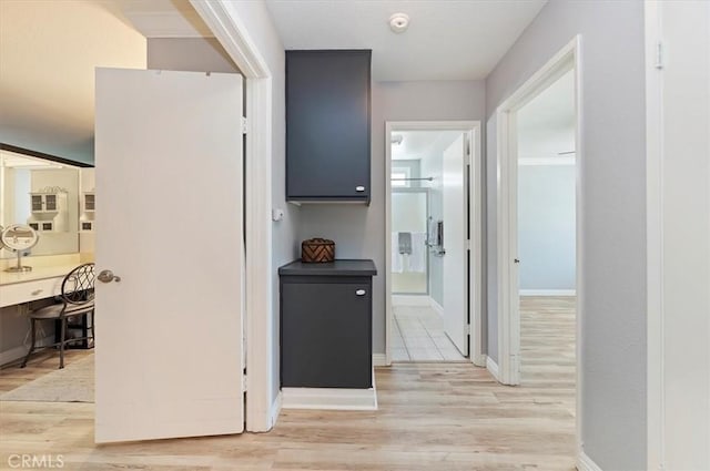 hallway with light wood-style floors and baseboards