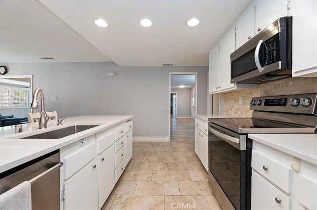kitchen featuring decorative backsplash, a sink, visible vents, stainless steel appliances, and light countertops