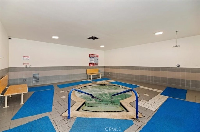 interior space with a wainscoted wall, tile patterned flooring, and community basketball court