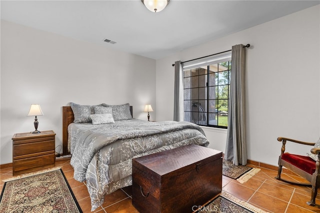 bedroom featuring tile patterned flooring, visible vents, and baseboards
