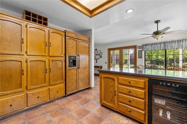 kitchen featuring beverage cooler, dark countertops, recessed lighting, a ceiling fan, and brown cabinetry