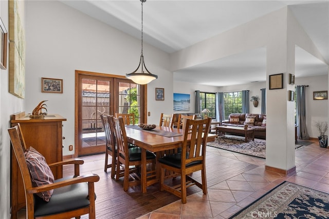 dining space featuring high vaulted ceiling