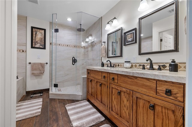 full bathroom with double vanity, visible vents, a stall shower, and a sink
