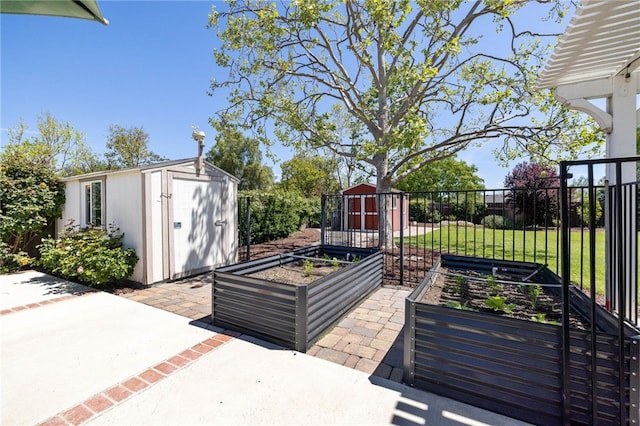view of patio featuring an outdoor structure, a storage shed, a vegetable garden, and fence