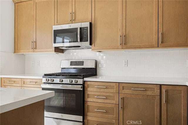 kitchen featuring backsplash, appliances with stainless steel finishes, and light countertops