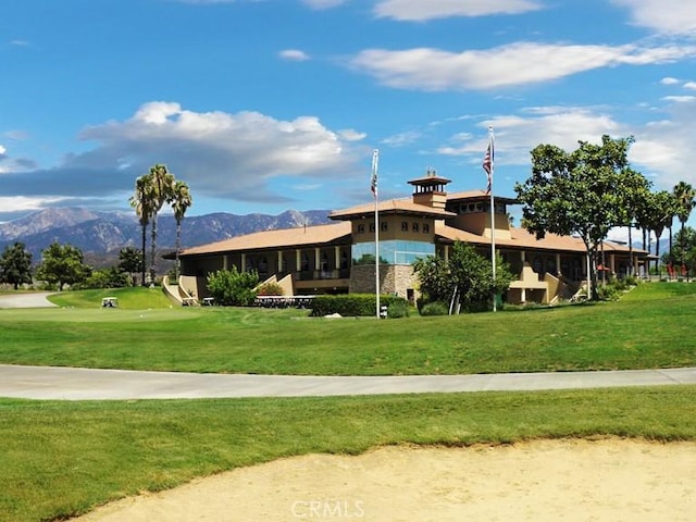 exterior space with a mountain view and a front lawn