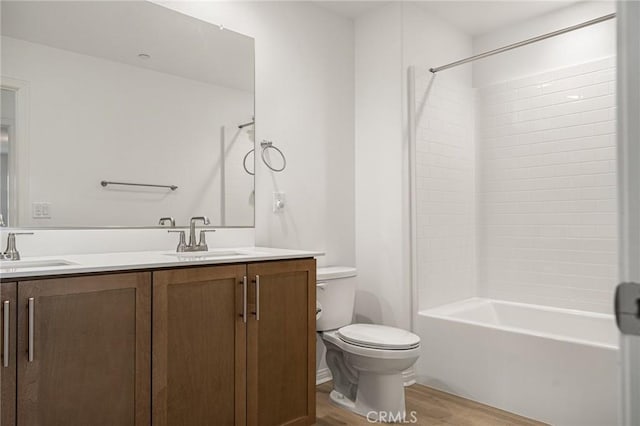 full bathroom featuring wood finished floors, toilet, double vanity, and a sink