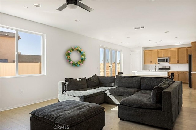 living area featuring recessed lighting, light wood-style flooring, ceiling fan, baseboards, and visible vents