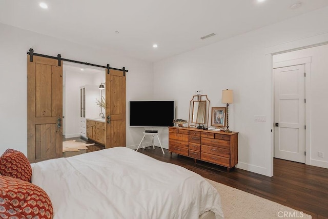 bedroom featuring visible vents, wood finished floors, baseboards, recessed lighting, and a barn door